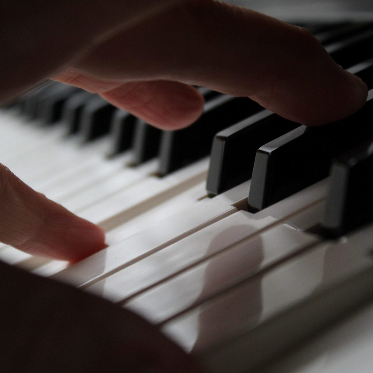 persons hand on piano keys