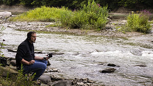 Photo of man recording river